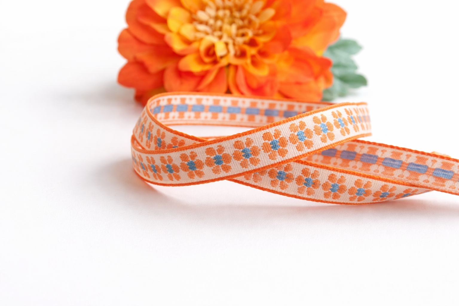 Tekstlint bloem oranje en blauw, per meter